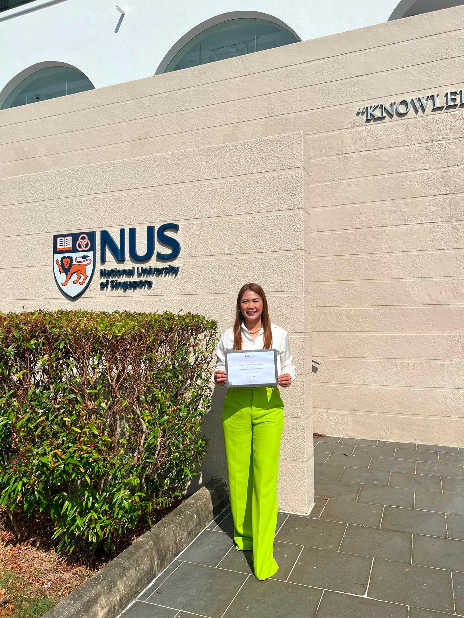 Konsehala Cecille Pagaling holding her certificate at the National University of Singapore